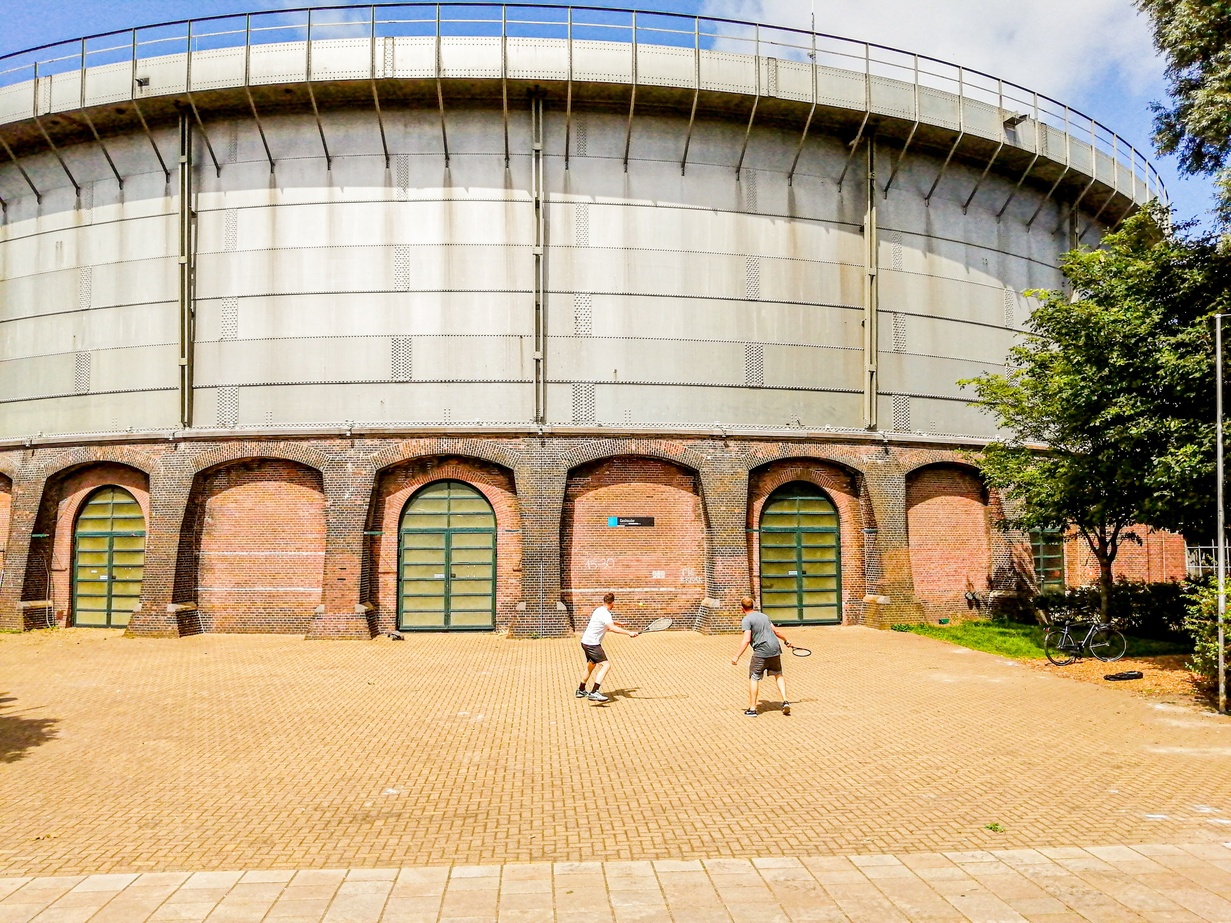 Tennissers spelen tegen de muur aan de Gashouder van Westergas, in Amsterdam
